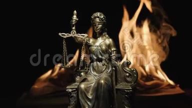 一本燃烧着的书的火焰背景上的女法官雕像